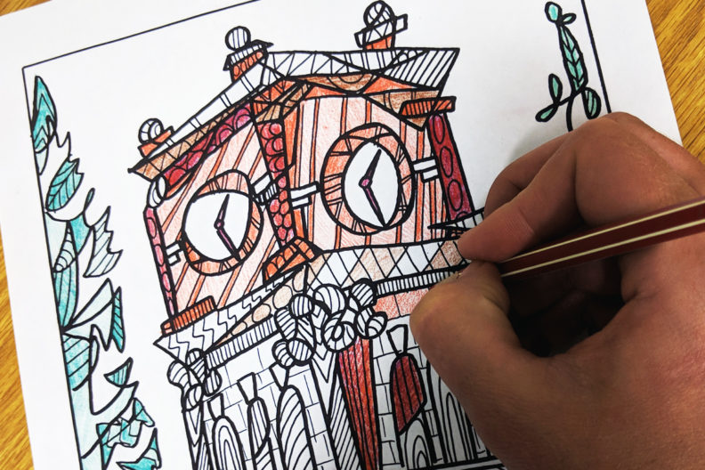 A person coloring a custom image of Bryan Hall.