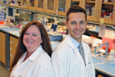 Rita Fuchs, left, and Ryan McLaughlin in a lab posing in profile