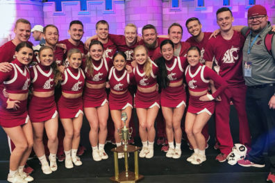 WSU cheer squad standing behind their trophy as they pose for a picture.