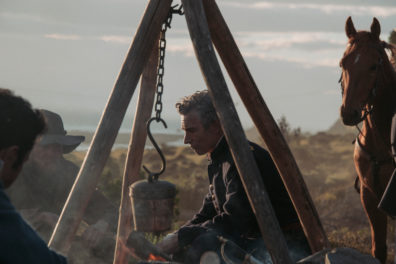 Frontiersmen seated around a campfire