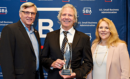 Danny House, owner of Dan the Sausageman gift baskets in Burien (center), receives SBA 2018 Small Business Person of the Year award. Rich Shockley and Jennifer Dye on on left and right, respectively, are SBDC business advisors at Highline College.