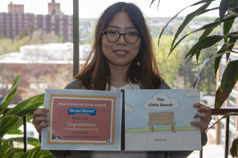 Ku shows award and book cover