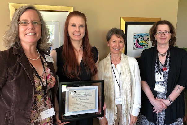 four women, one with a plaque