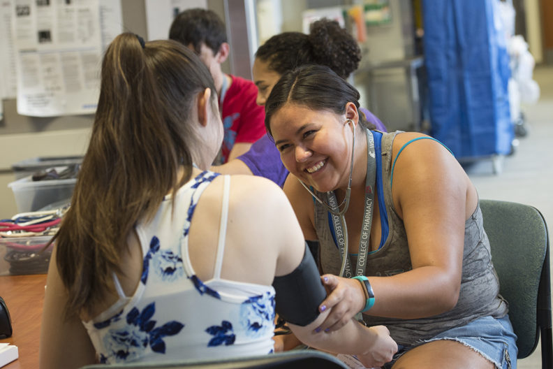 student taking the blood pressure of another student