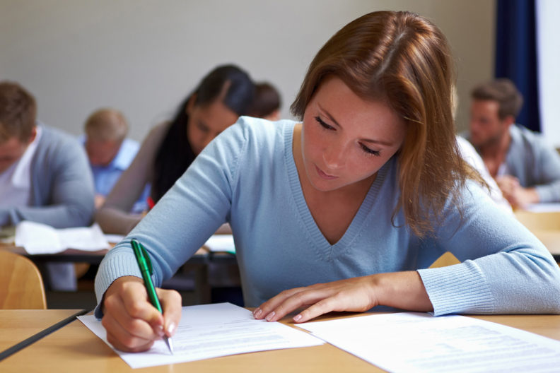 Student at desk filling out paper.