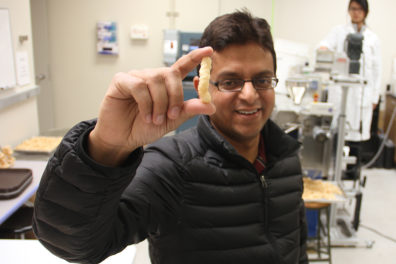 Ganjyal holding up a puff snack.