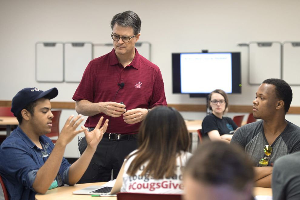 Mixter listens to a student during a classroom discussion.