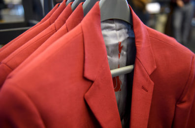 Crimson sport jackets hanging on coat rack.