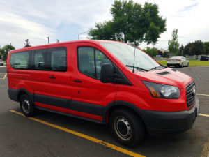 Red van sitting in parking lot.