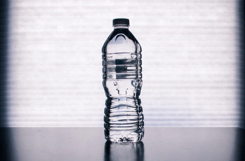 Plastic bottle of water on countertop.