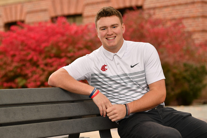 Hecker sitting on outdoor bench on Pullman campus.