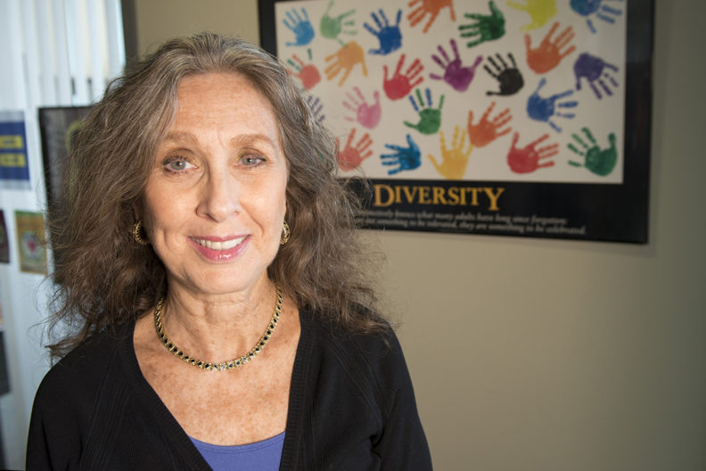 Closeup of Dedra Buchwald, MD, in front of a poster promoting diversity.