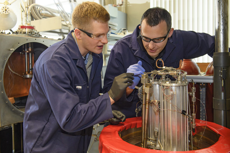 Leachman and Bunge examine research equipment in lab.