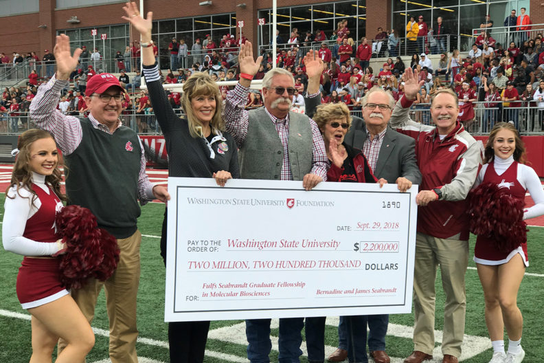 A large, ceremonial check is presented to WSU during a Cougar football game.