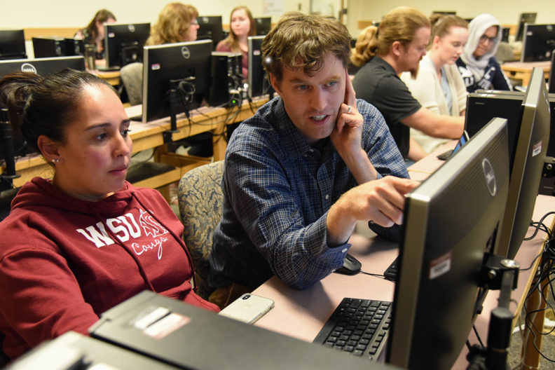 large computer education room with students and instructors