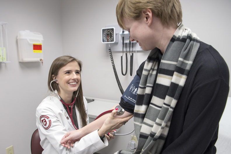 Medical student takes patient's blood pressure.