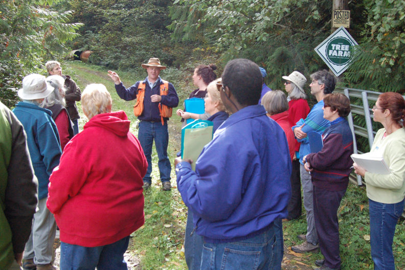 WSU forester speaking to large group of people at a tree farm.