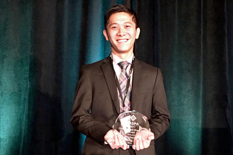 Nguyen on stage with award.