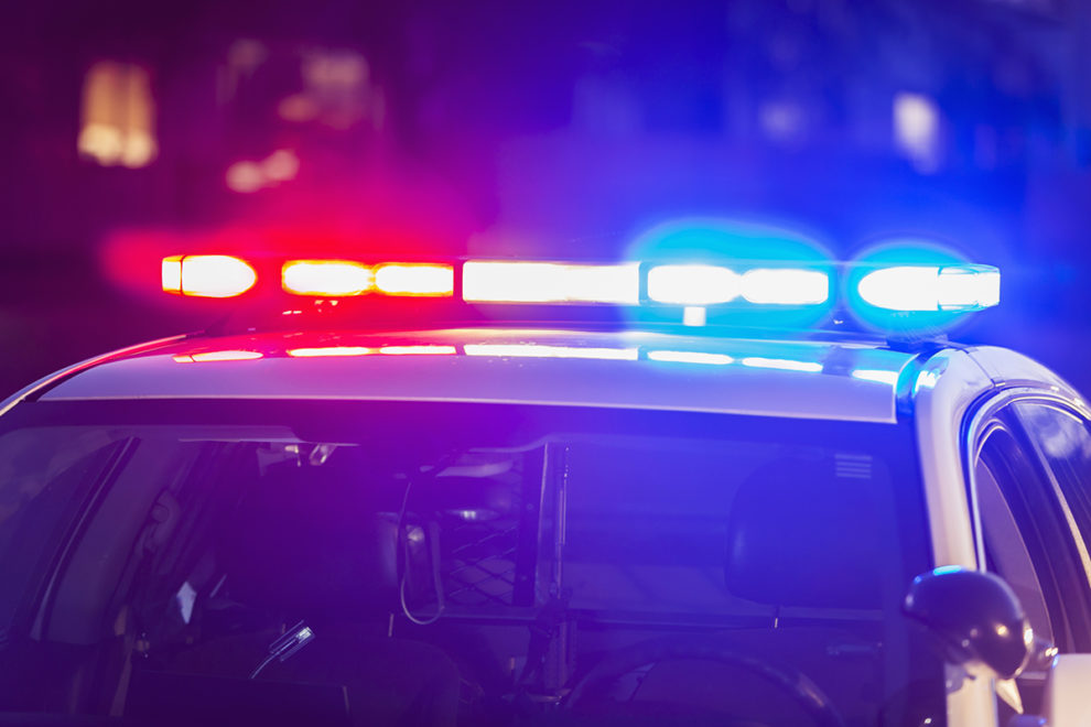 Lights flashing on the roof of a police car.