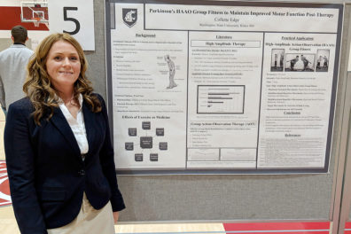 Edge standing beside research poster.