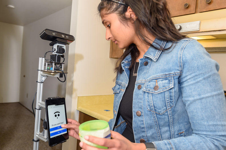 Raghunath interacts with helper robot at WSU Smart Apartment.