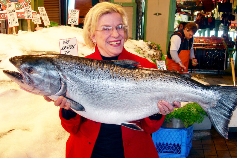 Godden holding a giant fish at Pike Street Market.