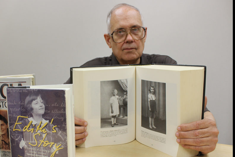 Seeborg at table with several books from collection.