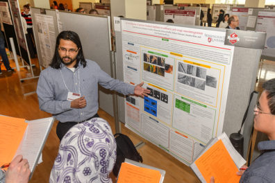 WSU graduate student sharing his research with others during Showcase.