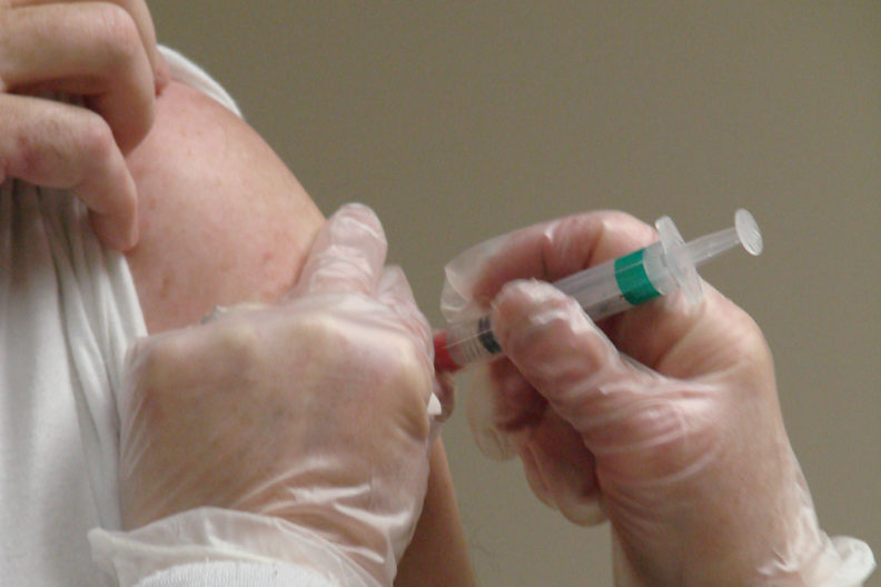 Closeup of gloved hands giving an inoculation.