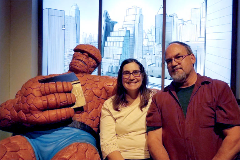 Jan and Mark O'English sit on couch with Marvel hero The Thing.