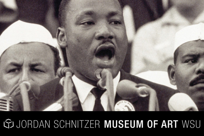 Martin Luther King, Jr. speaking into microphones.