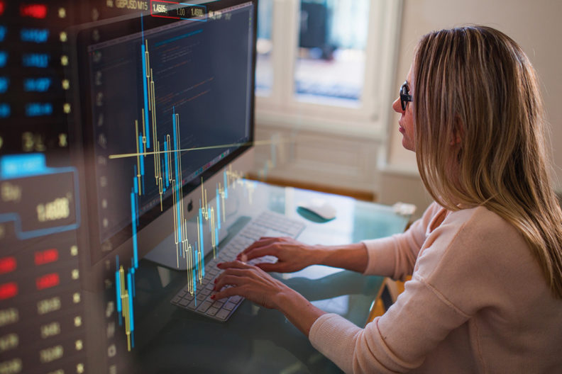 Business charts and a woman typing on a computer keyboard.