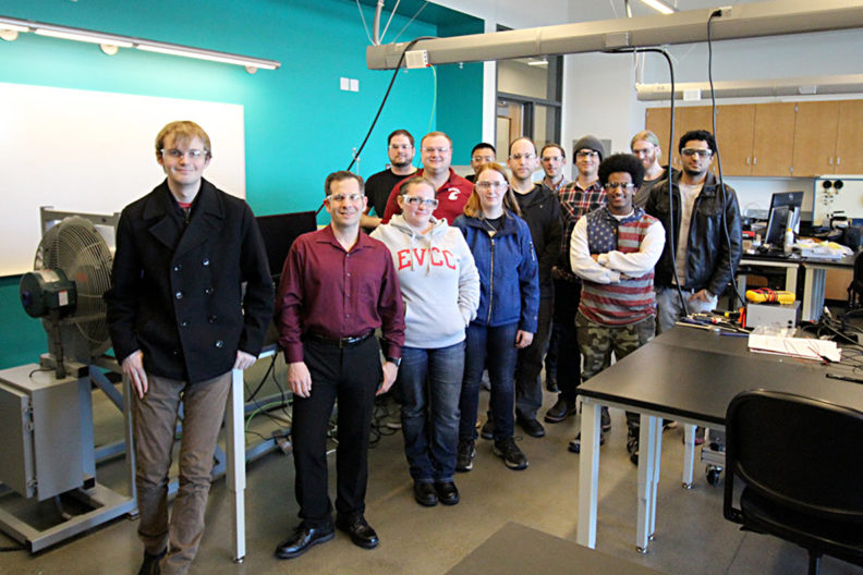 Club members standing together in a classroom.