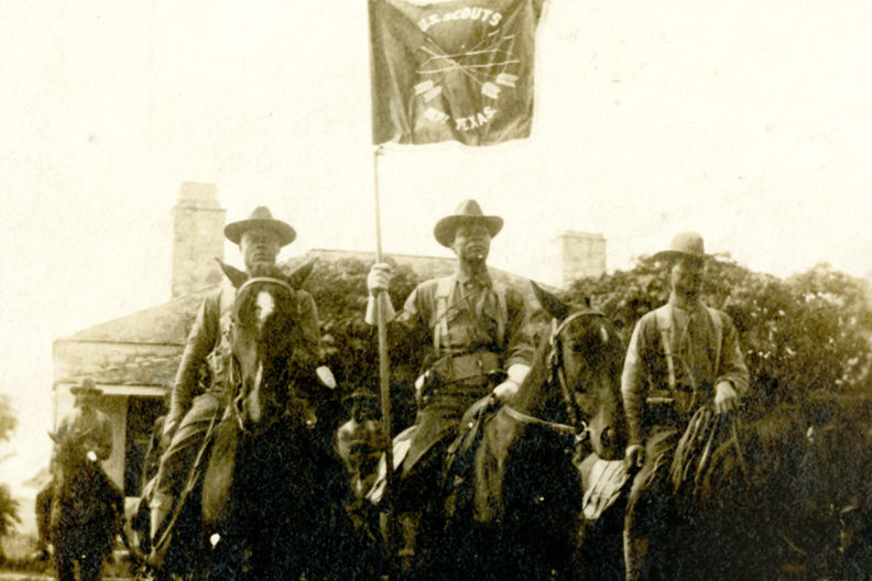 Three Native American scouts on horseback.