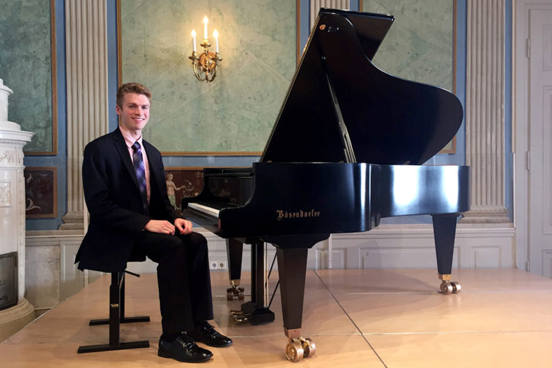 Garrett Snedeker seated at piano.