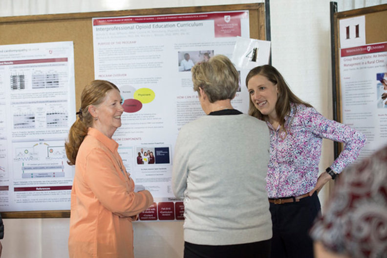 Jaclyn Thatcher, right, talks about her project on group medical visits for patients with chronic pain.