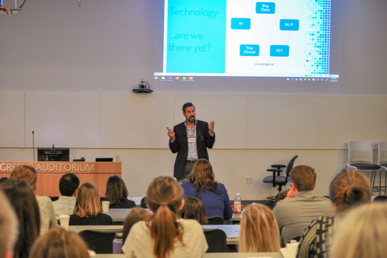 Steve Riddle speaks to a group of people in an auditorium.