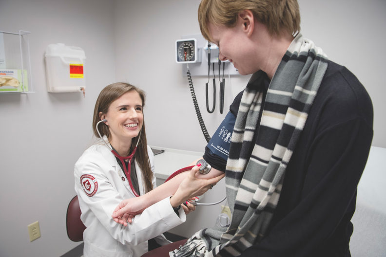 Medical student examines a patient.