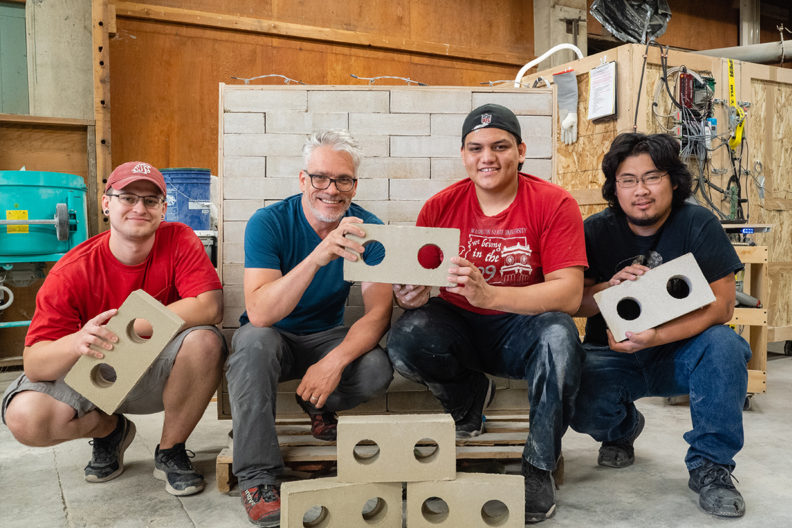 DWB team members hold pieces of their new drywall building material.