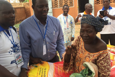 David Oni, left, and Abel Saba, right, help distribute the two tons of rice they brought to Burkina Faso.