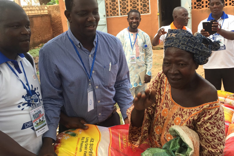 David Oni, left, and Abel Saba, right, help distribute the two tons of rice they brought to Burkina Faso.