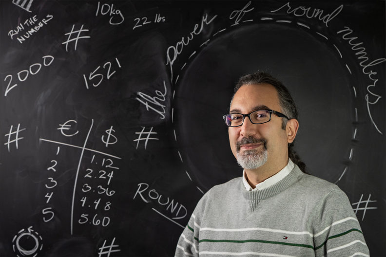 Kunter Gunasti in front of a chalkboard.