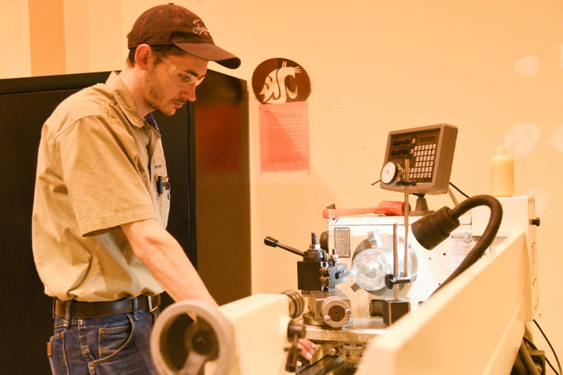 WSU Tri-Cities student engineer Bryan Chronister works in the engineering high bay to craft an instrument prototype.