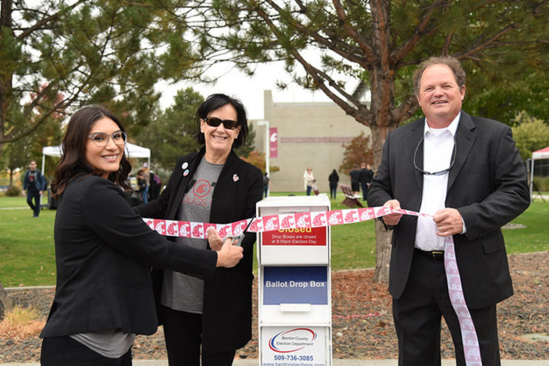Three people cut the ribbon on WSU Tri-Cities' first ballot box.