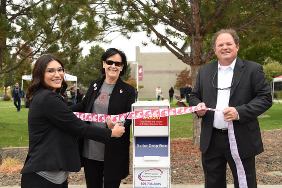 Three people cut the ribbon on WSU Tri-Cities' first ballot box.