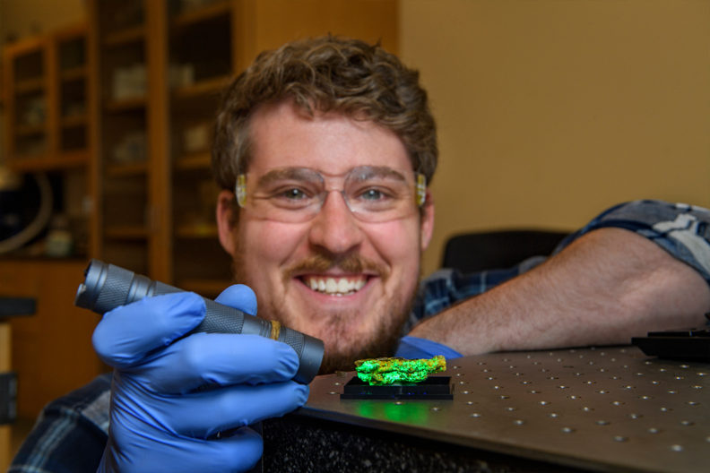A researcher shines a light on a mineral sample.