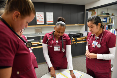 Nursing students talking around a table.
