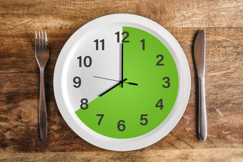 A place setting with a dinner plate that resembles a clock.