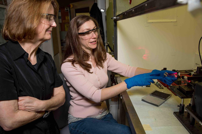 PNNL chemists Sue Clark (left) and Amanda Lines (right) evaluate a laser-based on-line monitoring system for radionuclides in the Radiochemical Processing Laboratory.