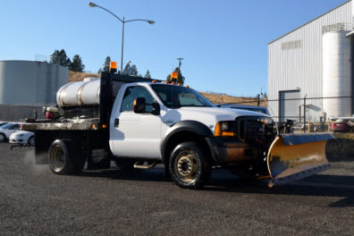 Truck fitted with a snow plow blade and de-icer.